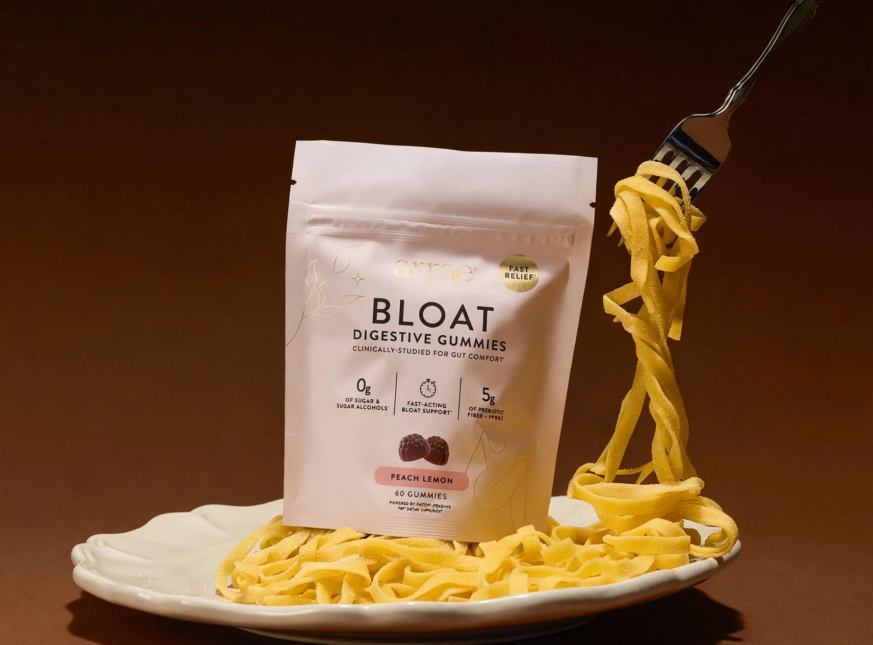 Bloat digestive gummies displayed beside lifted pasta on a fork.