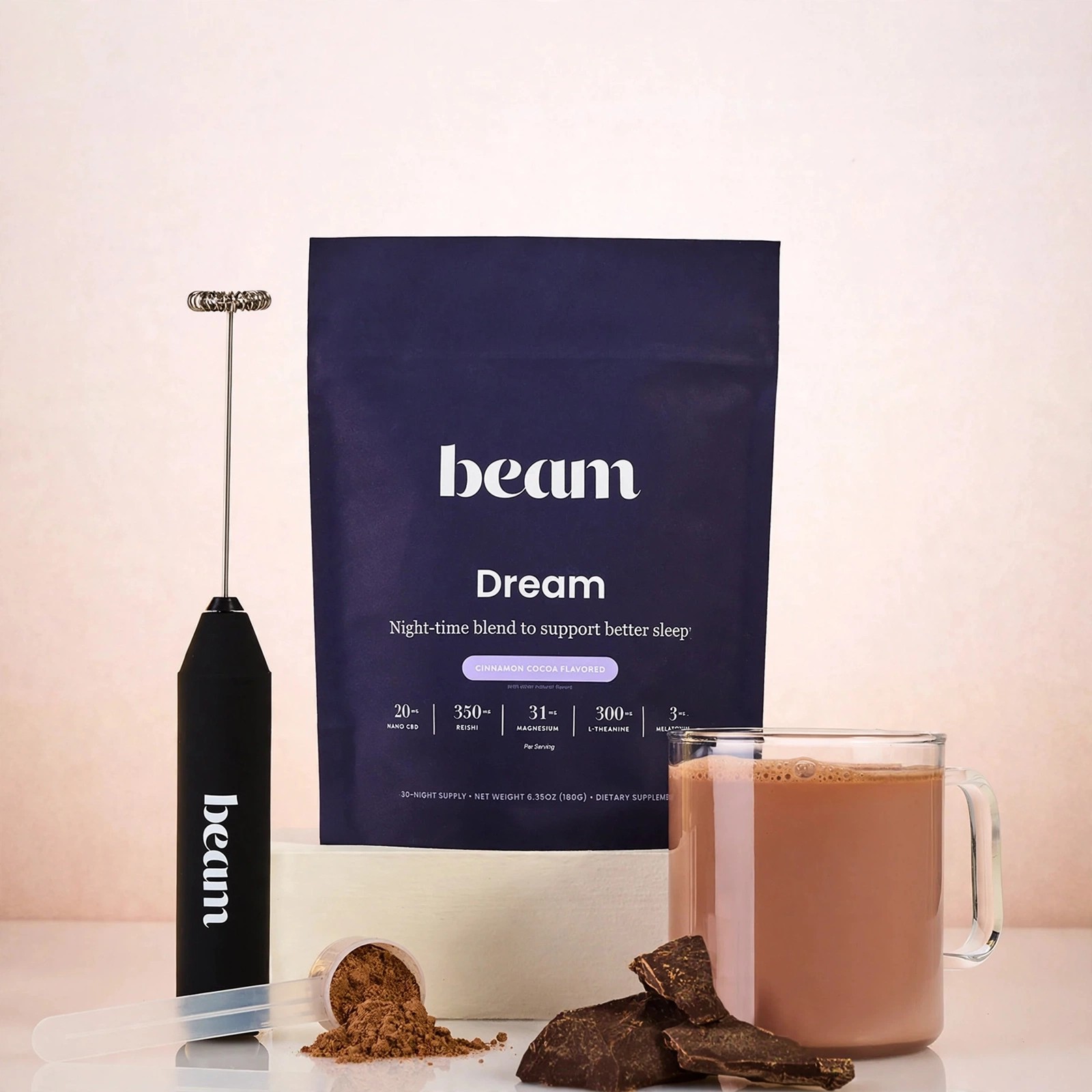 A prepared Dream drink with its packaging, cocoa pieces and mixer.