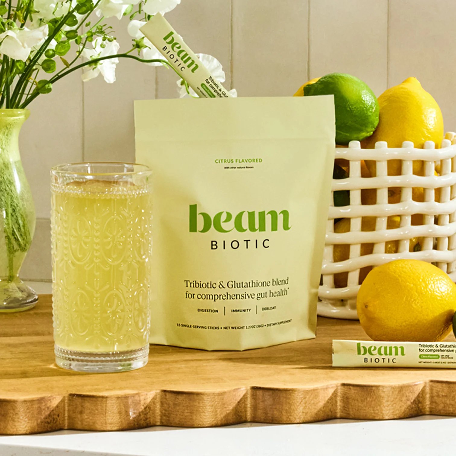 Citrus Biotic blend beside a full glass on a wooden board.