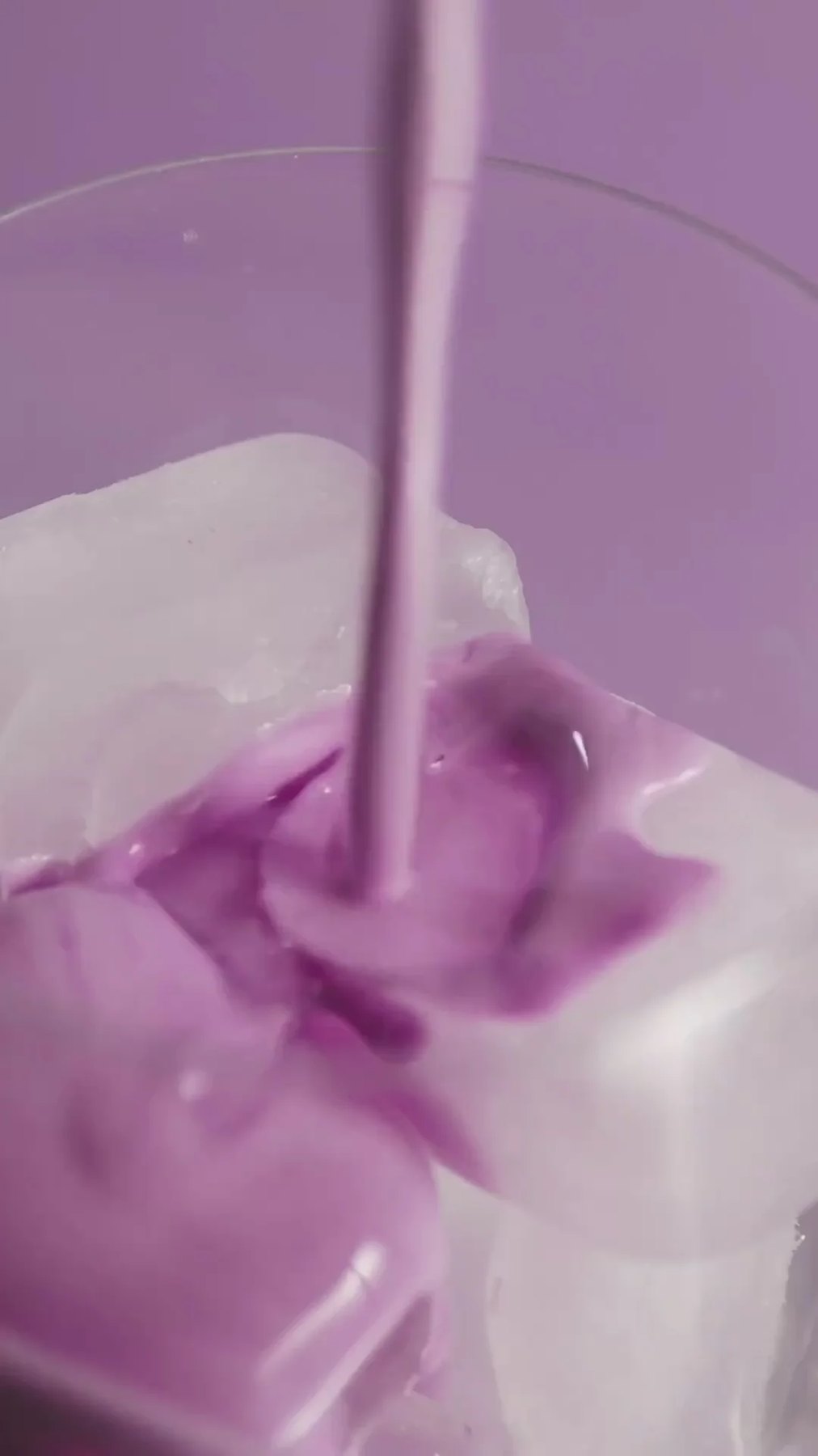 Iced glass being filled with a purple collagen beverage.