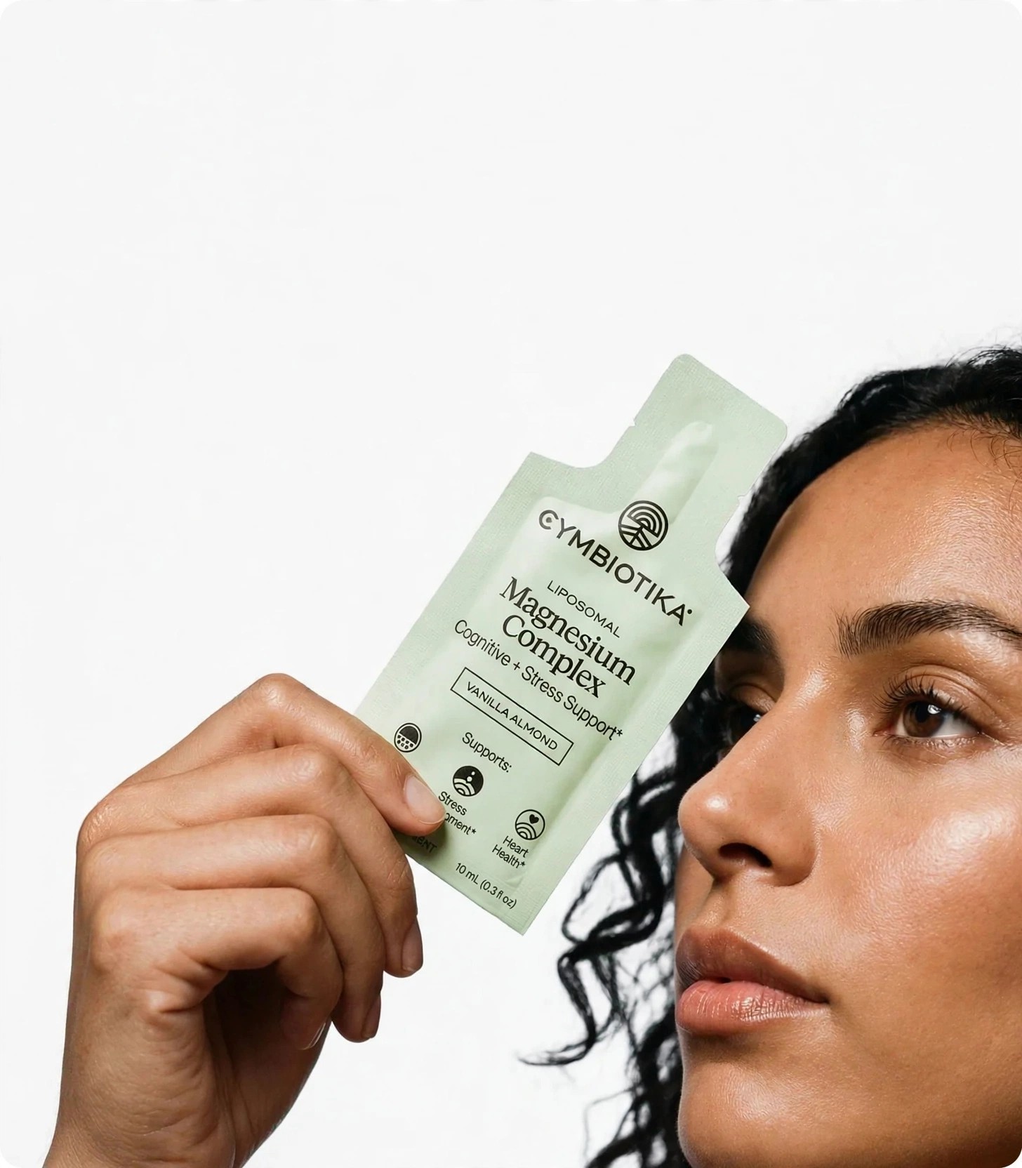 Close crop of model displaying Cymbiotika Magnesium Complex packet.