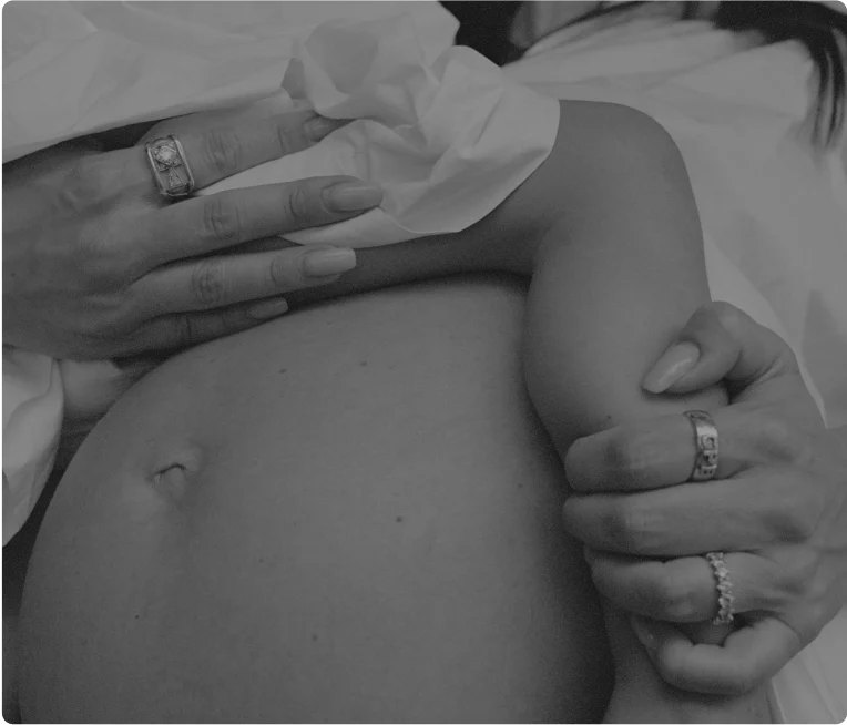 Black and white close up of pregnancy with hands.